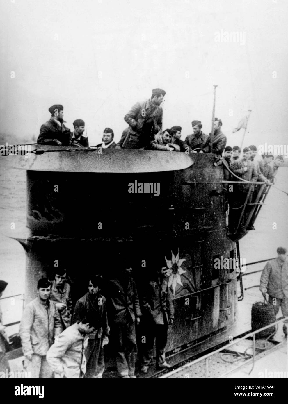 WW2: l'equipaggio di un sottomarino nazista di rivestimento del conning tower e sul ponte della nave sul loro ritorno alla loro base. Nota le figure delle fiamme battenti dal conning tower. Queste cifre sono presunti per rappresentare il tonnellaggio delle navi U-boat ha affondato durante il suo viaggio. Xiii Febbraio 1942. Foto Stock
