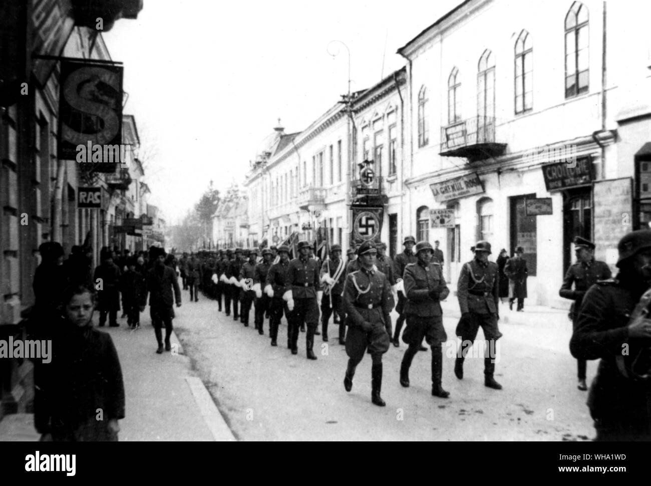 WW2: Romania/ truppe tedesche in testa attraverso la città dietro i loro standard divisionale. Foto Stock