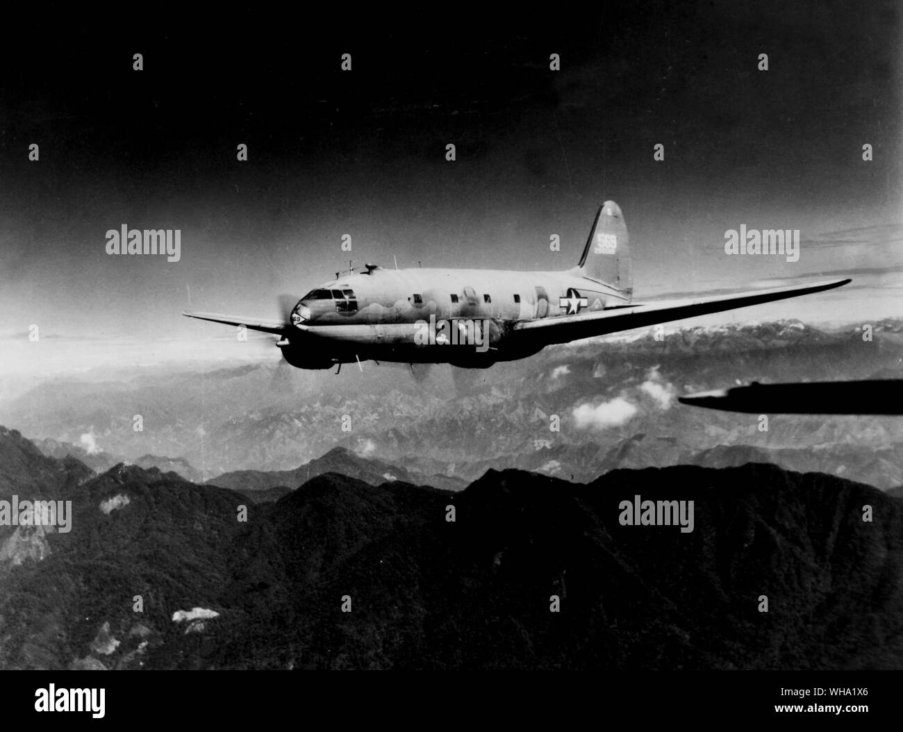 WW2: Curtiss C-46 Commando oltre la cresta di fuoco della gobba in rotta verso la Cina lungo i percorsi della divisione India-China, il trasporto aereo. Foto Stock