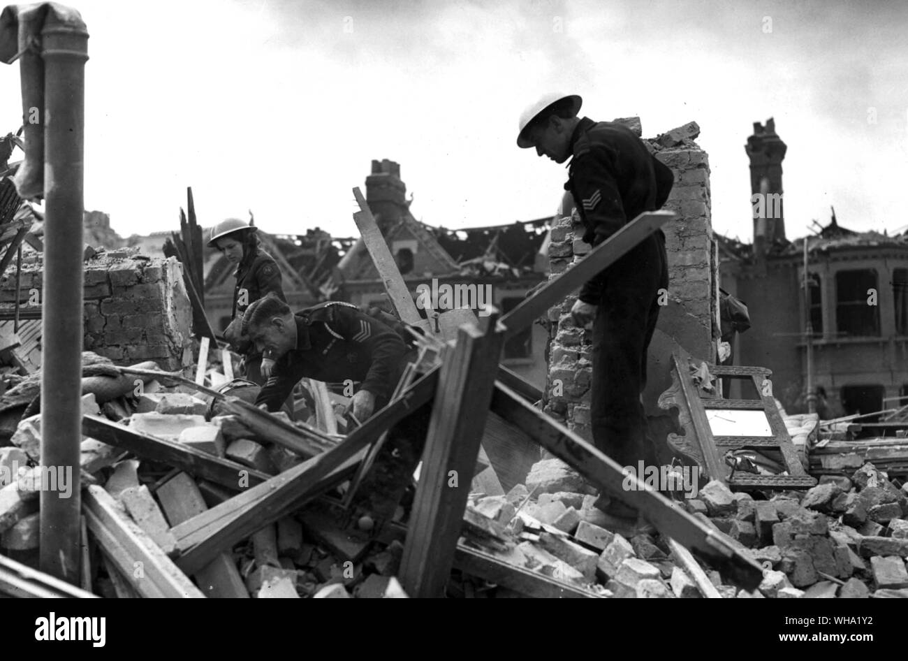 WW2: Sito di un incidente. Difesa civile soccorritori ascoltare e scavare per vittime intrappolata sotto cumuli di macerie. Foto Stock
