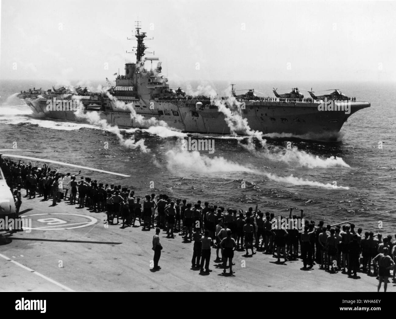 Saluto in Mar Rosso. HMS baluardo passando Albion in Mar Rosso al accompaniament di un saluto di verey colpi di pistola. Albion sta andando a casa dopo diciotto mesi in Estremo Oriente e baluardo sta prendendo su di lei a est di Suez impegno. Settembre 1966 Foto Stock