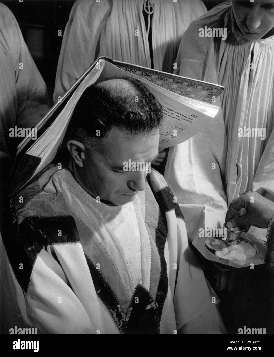 Un Vescovo è ordinato per la pienezza del sacerdozio e, come un segno della Parola di Dio che egli ha per predicare il libro dei Vangeli viene posato sulla sua testa. Foto Stock