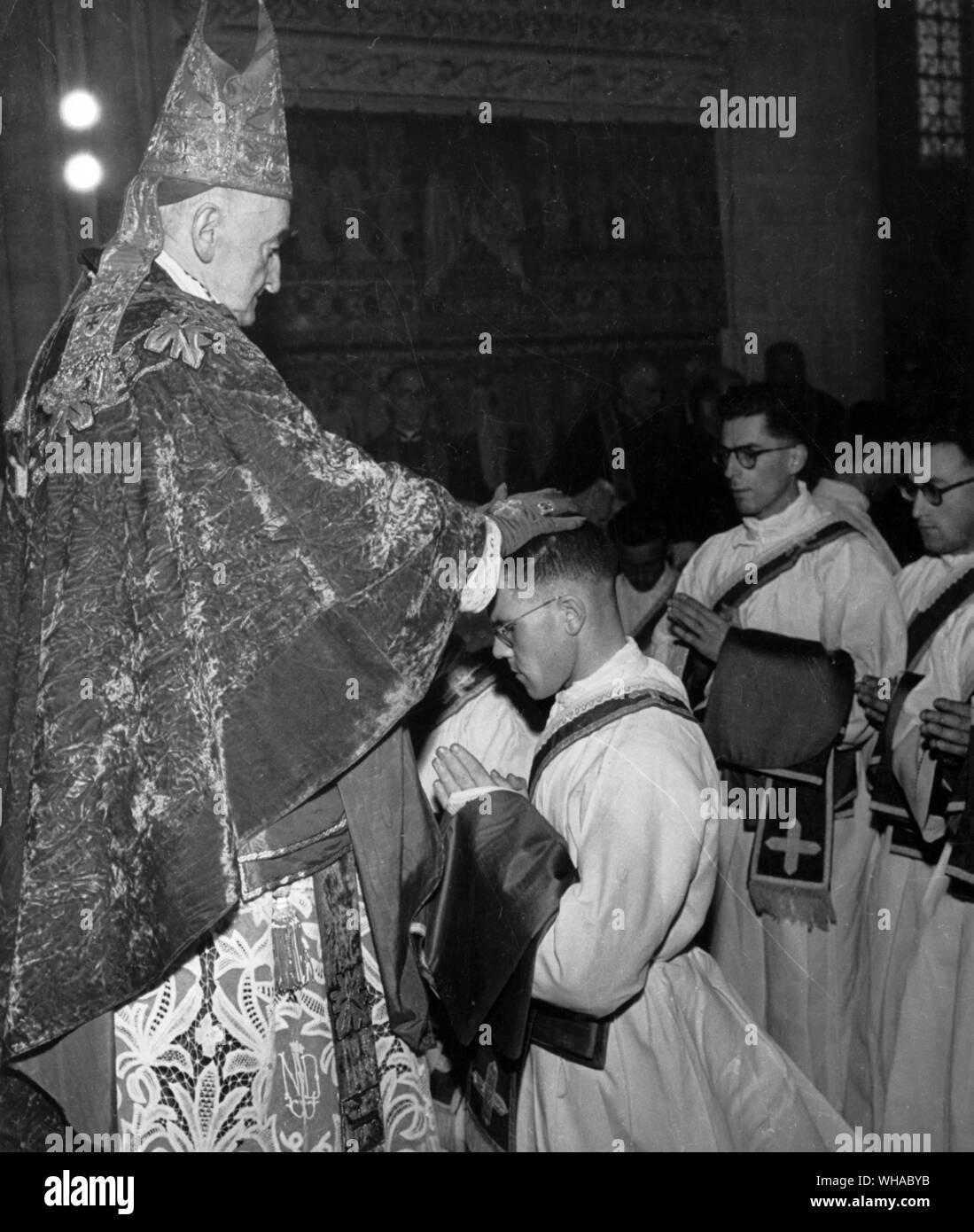 L'ordinazione. Il Vescovo pone le proprie mani sui candidati seguiti da tutti gli altri sacerdoti presenti, quindi li presenta con piviali e annoints le loro mani. Foto Stock