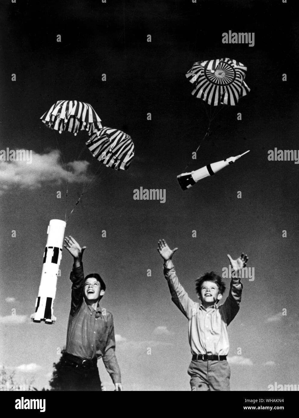 Due giovani rocketeers recuperare le due fasi di un Saturn V MODELLO DI razzo di ritornare sulla terra da paracadute dopo un lancio di successo Foto Stock