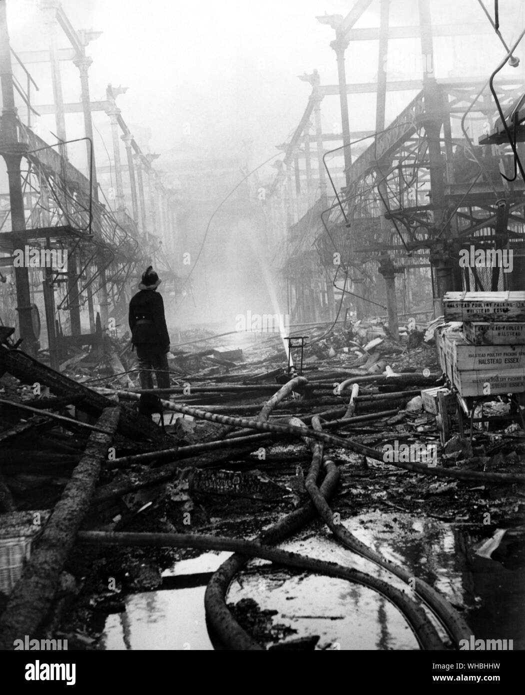 Di scena a Smithfield dopo l'incendio. . I vigili del fuoco lo smorzamento nella hall principale. . 1958 Foto Stock