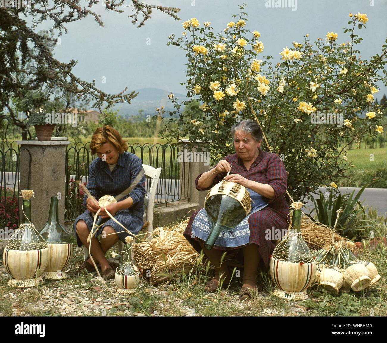 Rendendo Fiaschi copre nella campagna toscana. . Un fiasco è un tipico stile italiano della bottiglia, di solito con un corpo rotondo e basso, parzialmente o completamente coperto con uno stretto raccordo a cesto di paglia. . . Foto Stock