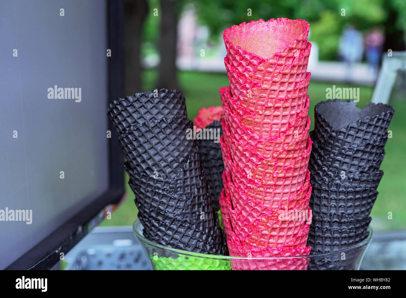 Coppe di wafer per gelato di rosso e nero. Coni di cialda sul contatore di un gelato venditore. Foto Stock