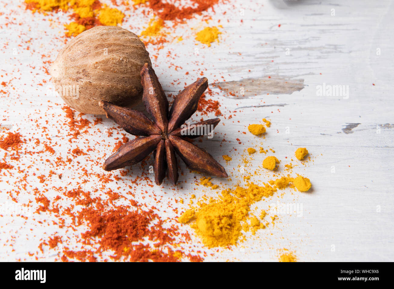 Bellissima cibo sullo sfondo delle spezie: set di anice stellato, curcuma, noce moscata in bianco sullo sfondo di legno. Spezie, ingredienti per la preparazione di vin brulé, Masal Foto Stock