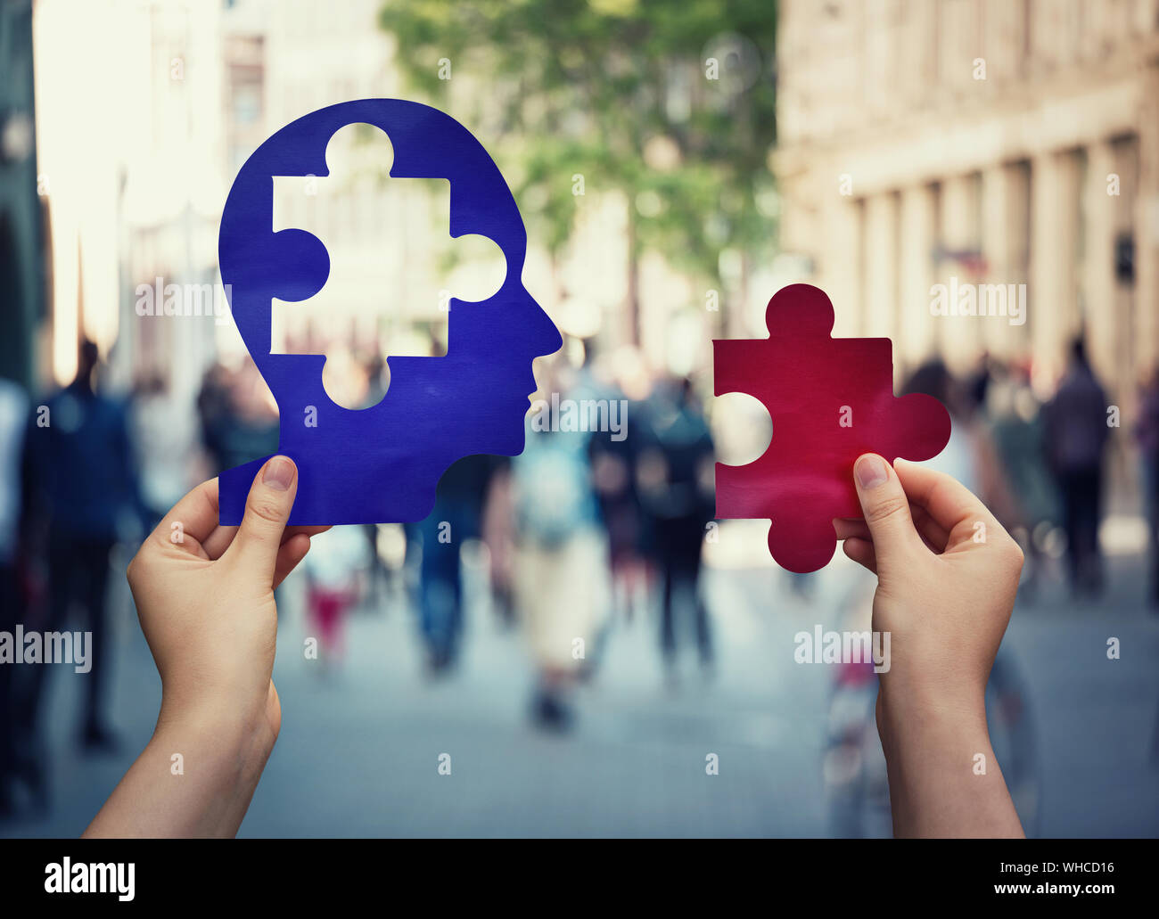 Due mani in possesso di una carta con testa umana e un pezzo di puzzle. Trovare una cura per guarire la malattia. La salute mentale concetto, perdita della memoria e demenza dise Foto Stock