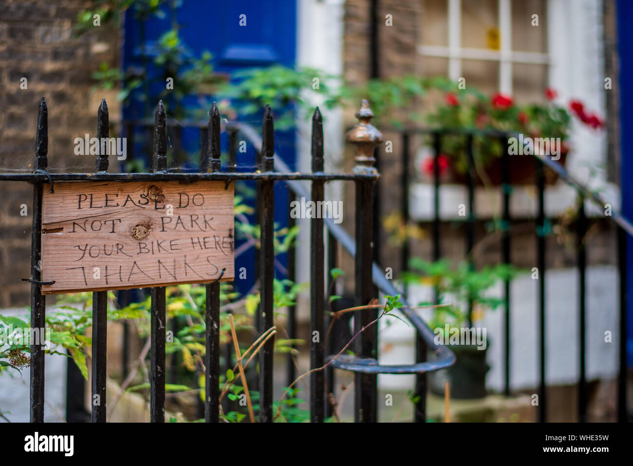 Bizzarre Cambridge - fatto a mano segno chiedendo "Si prega di non parcheggiare la bici qui grazie' sulle ringhiere al di fuori di una casa nel centro di Cambridge Regno Unito Foto Stock