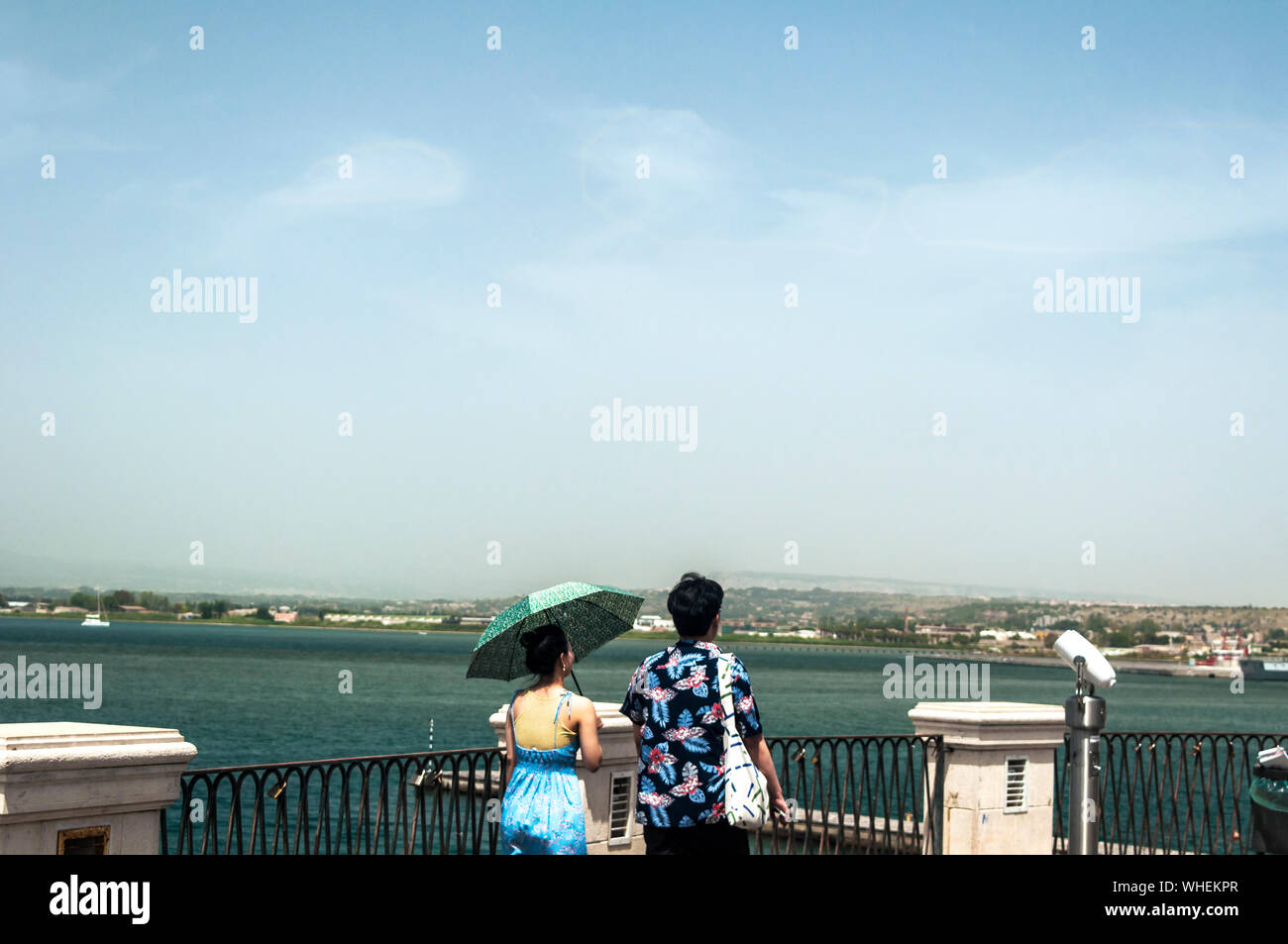 Un uomo e una donna che guarda sul mare Ionio in una calda giornata estiva in Ortigia, Siracusa, Sicilia. Foto Stock