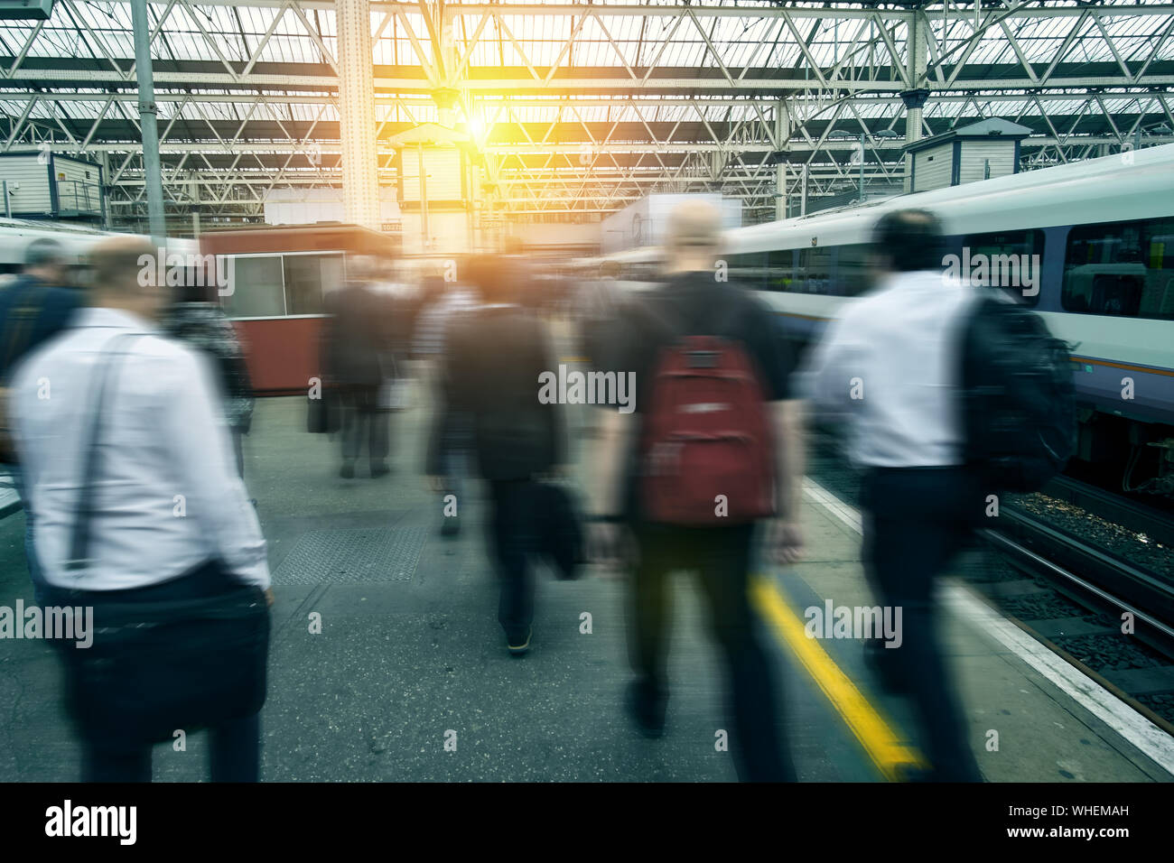 Rush Hour presso la stazione ferroviaria. La gente a piedi di " commuters ". Città sfocata i lavoratori e la gente di affari di andare a lavorare in fretta a Londra. Foto Stock