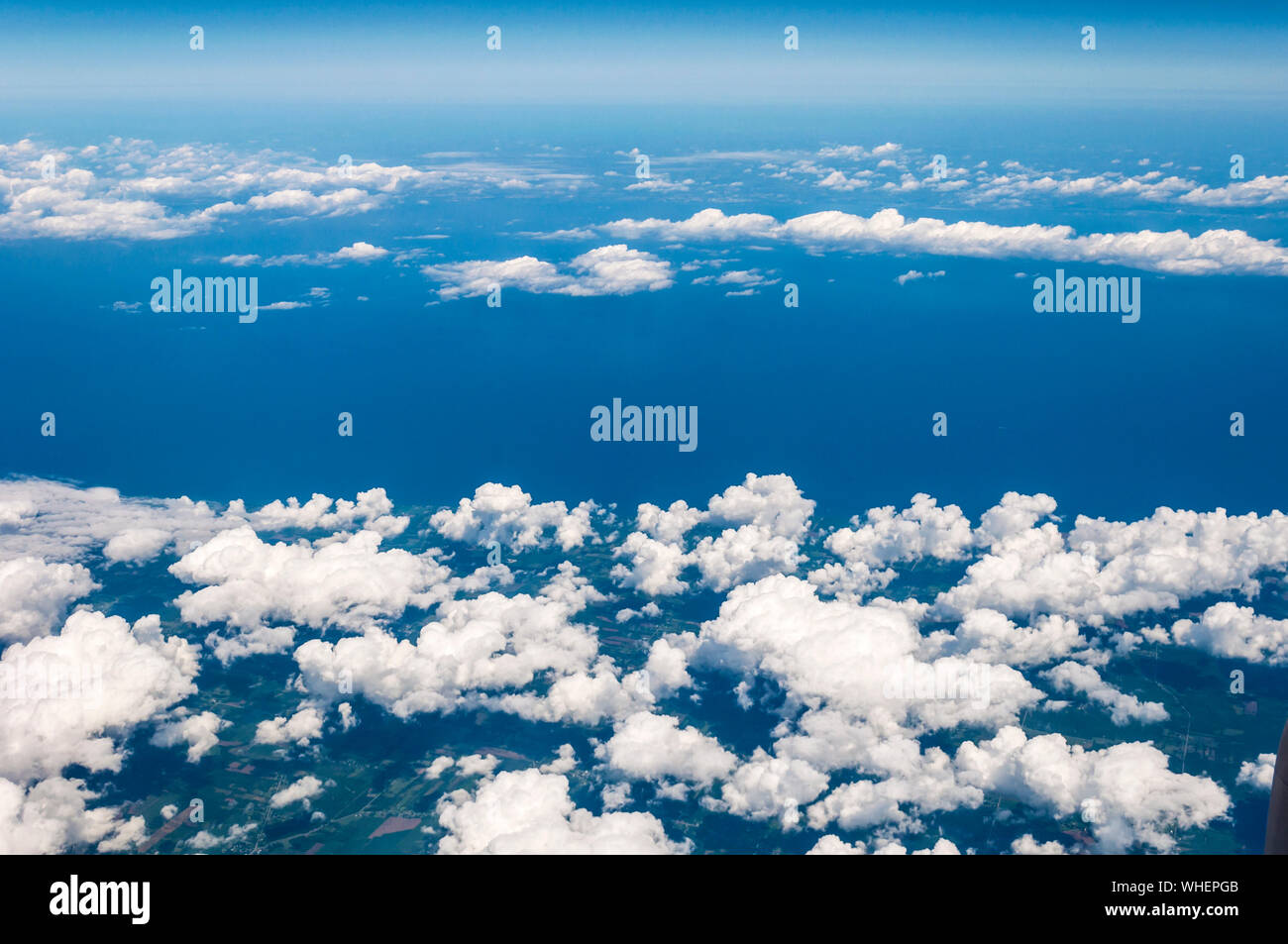 Vista aerea di dispersi, puffy nuvole, fotografata da un normale volo commerciale sull'Oceano Atlantico Foto Stock