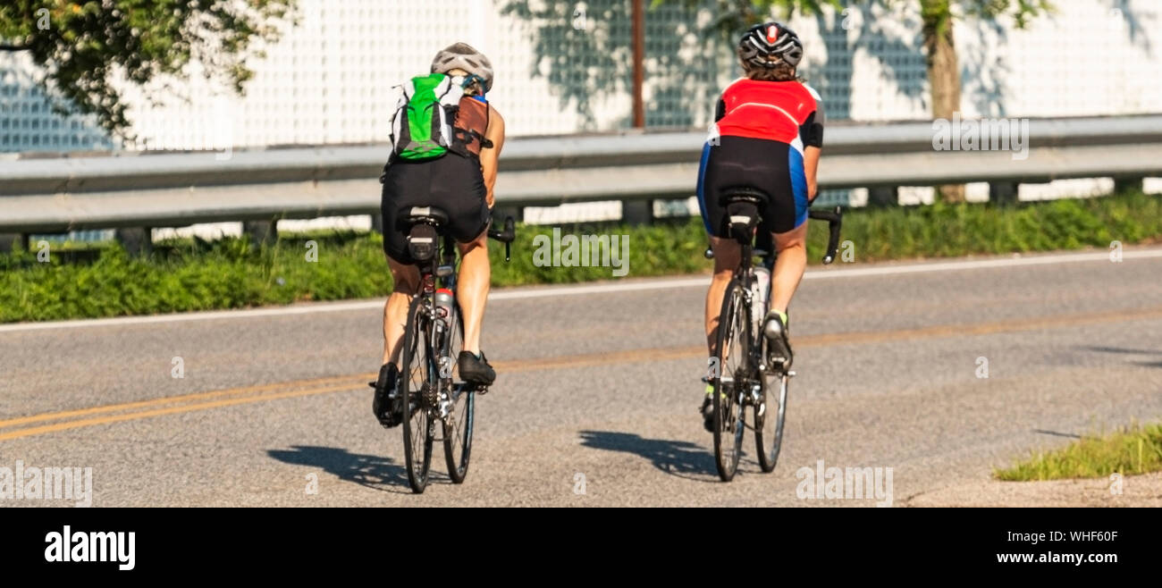 Due ciclisti sono la formazione per un triathlon su una strada vuota a fianco a fianco. Foto Stock