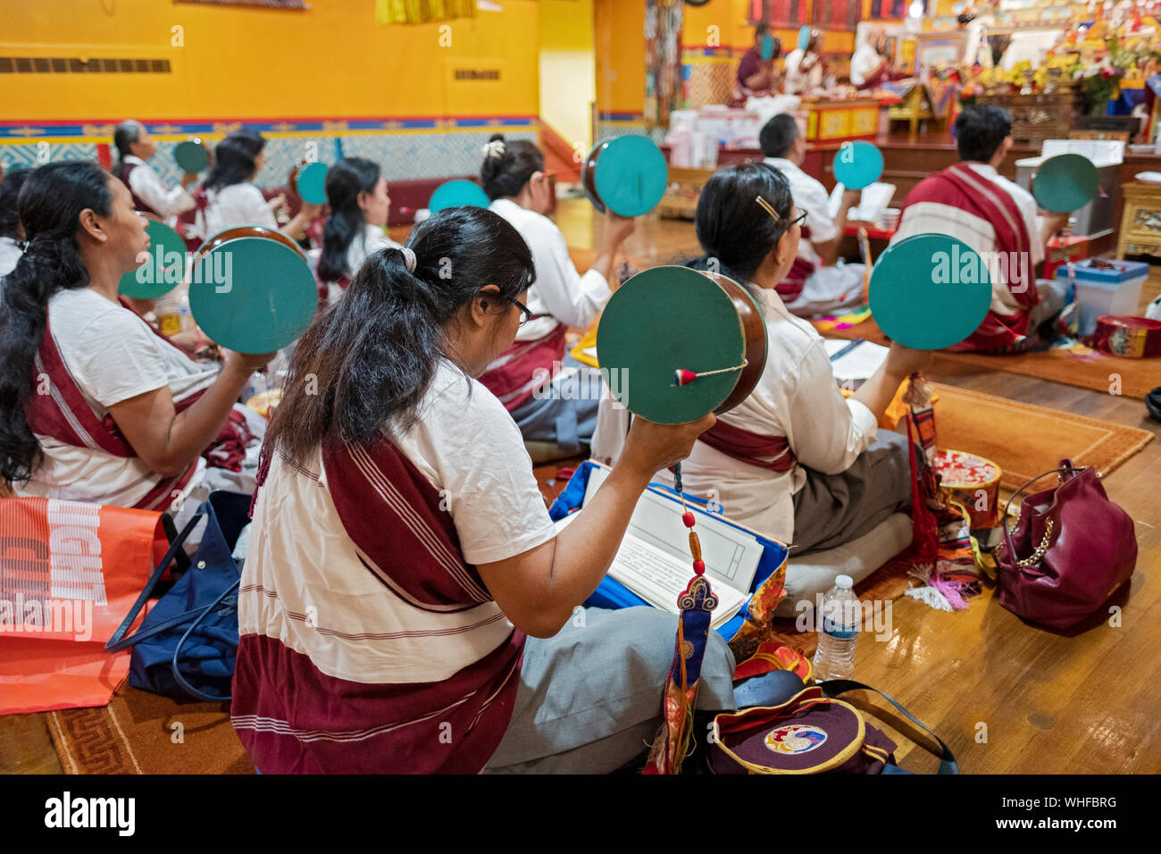 Devota & Nepalese buddista tibetano Donne a pregare in un tempio mentre la rotazione di un tamburo damaru. In Elmhurst, Queens, a New York City. Foto Stock