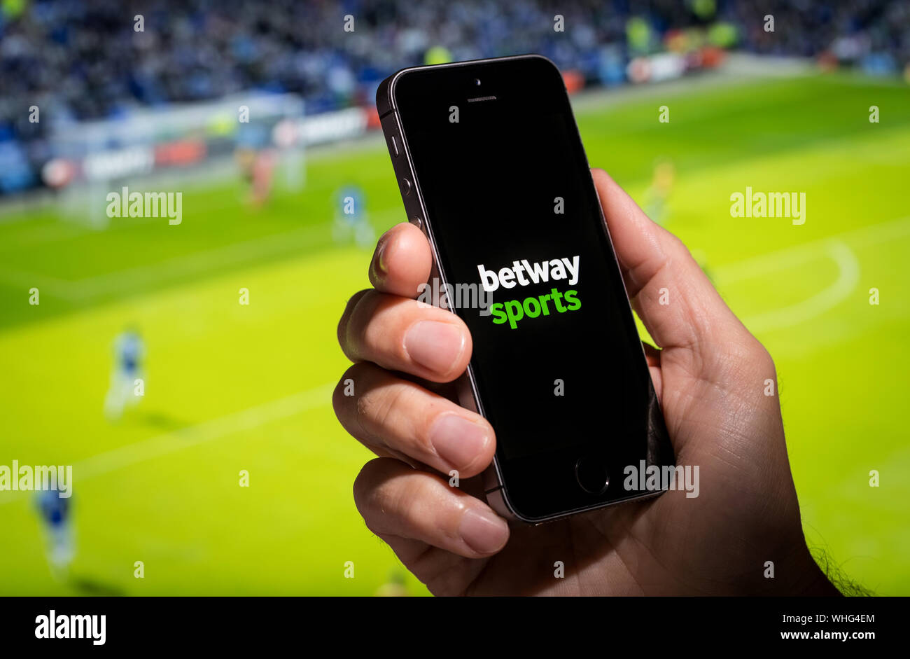 Un uomo che guarda il Betway Sport Sito web app mentre si guarda la partita di football Foto Stock