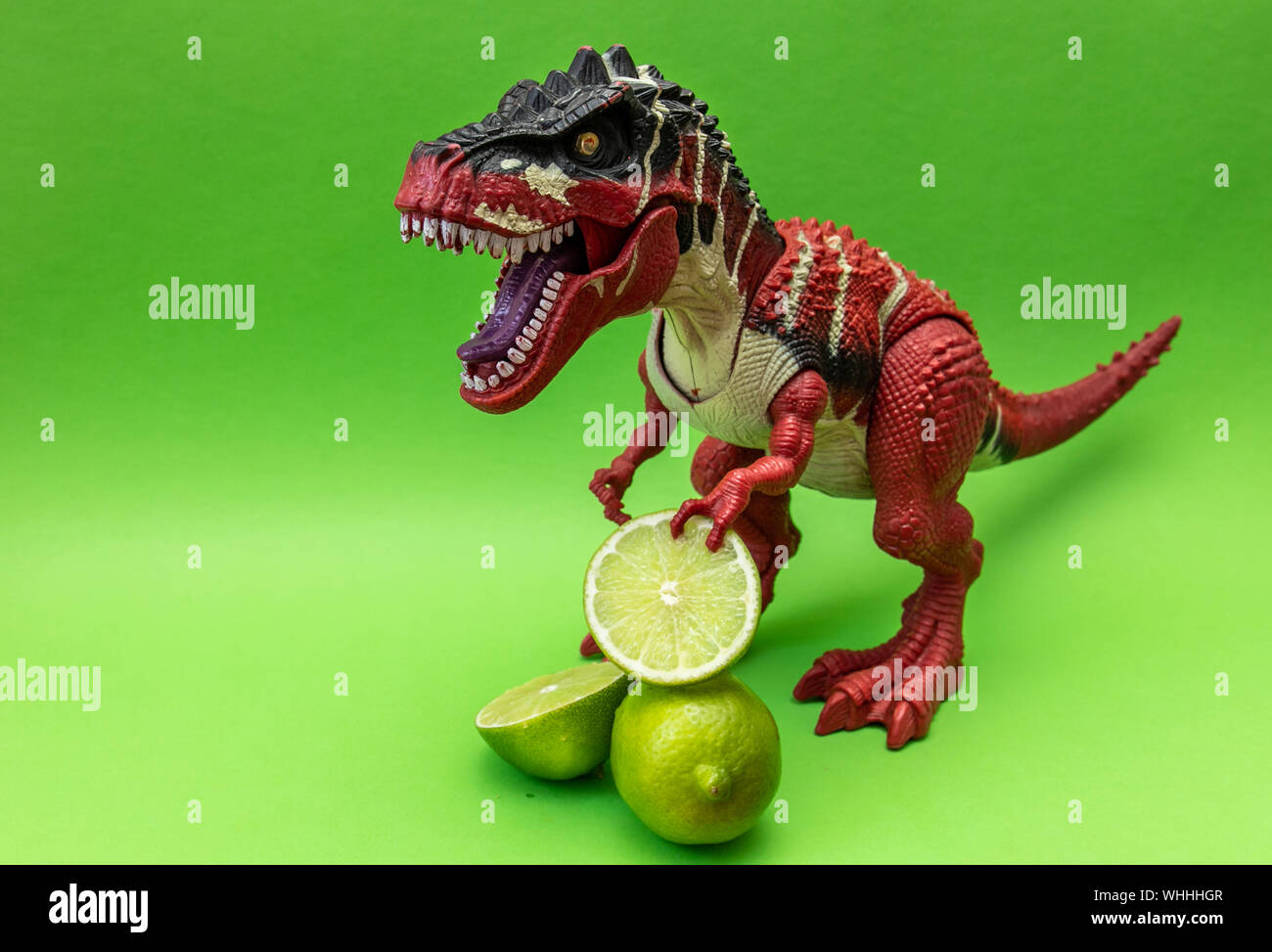 Rosso Tyrannosaur dinosauro con calce, isolato su sfondo verde, copia spazio per il testo Foto Stock