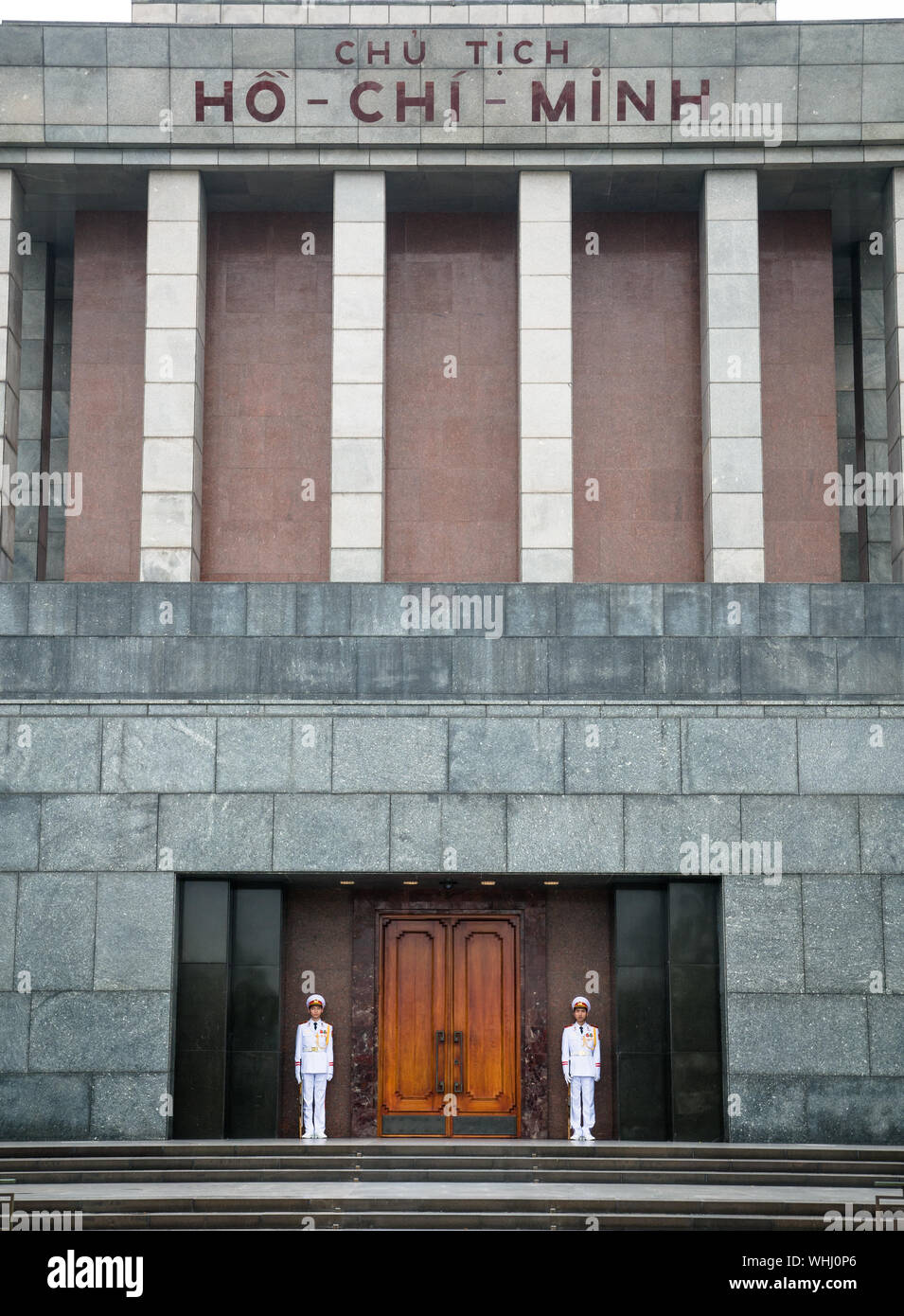Due custodi maschio che fissano Mausoleo di Ho Chi Minh ad Hanoi città vecchia, in Vietnam, in vista frontale, architettura comunista Foto Stock