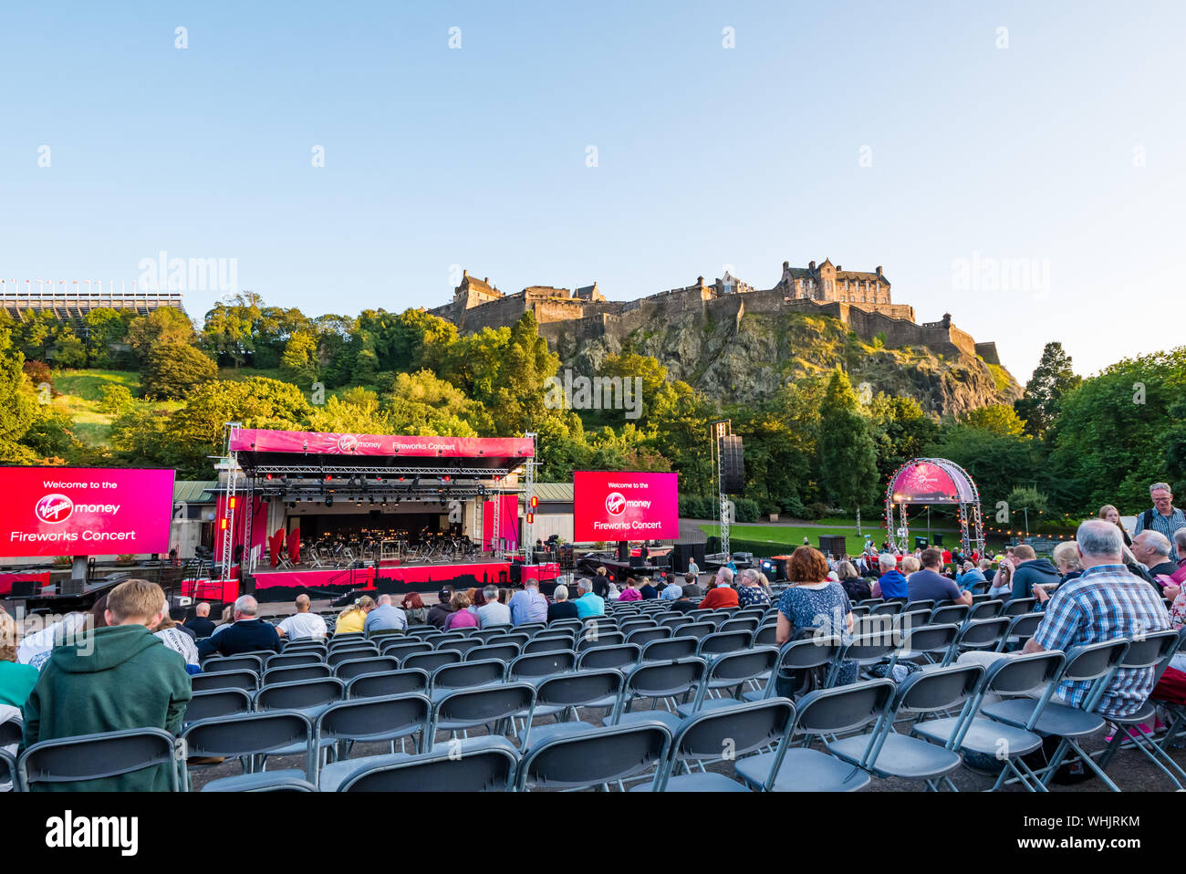 Pubblico in attesa di Vergine denaro concerto di fuochi d'artificio, Edinburgh International Festival 2019, con il Castello di Edimburgo nel sole di sera, Scotland, Regno Unito Foto Stock
