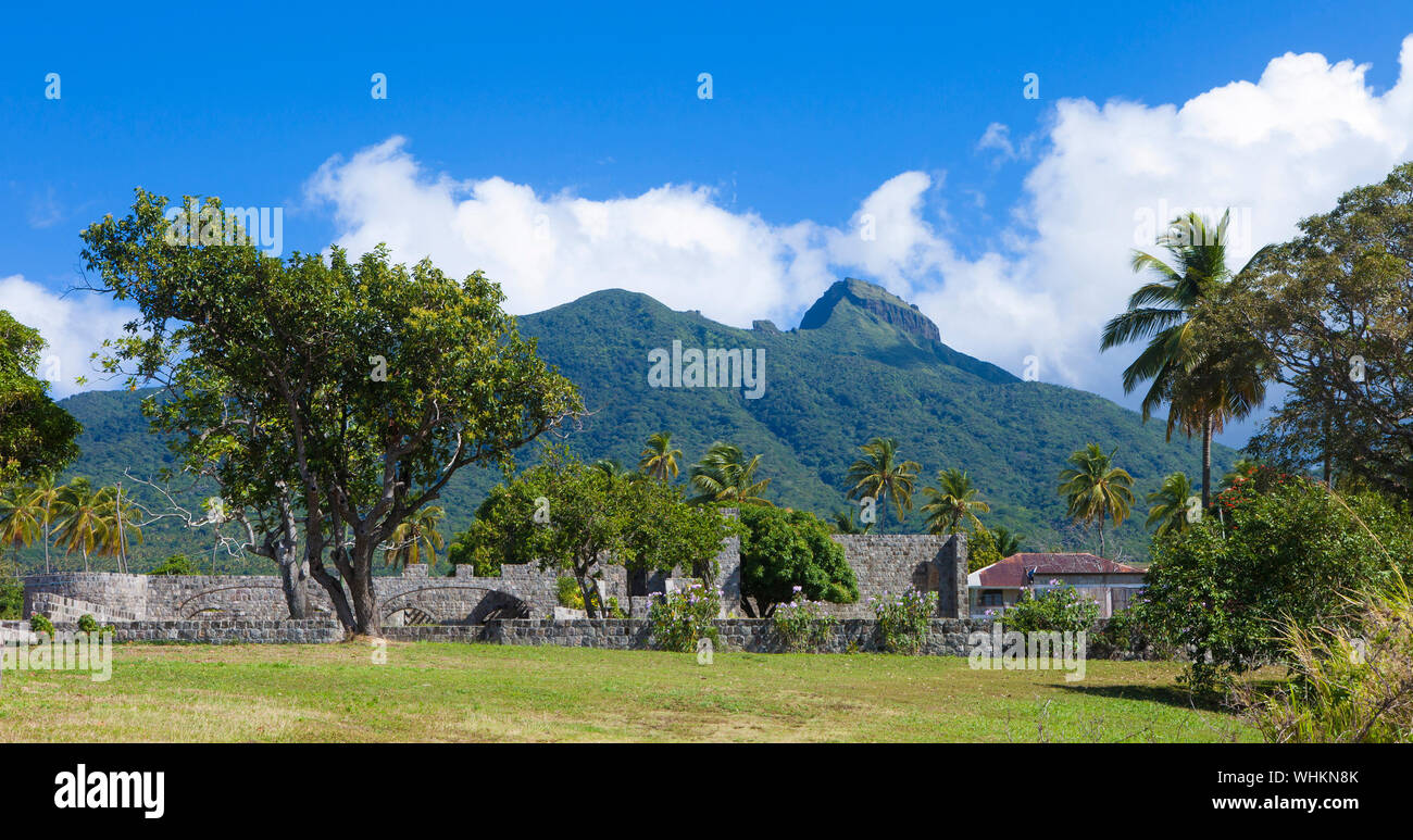 Le rovine di una piantagione di canna da zucchero con il vulcano in background, St Kitts. Foto Stock