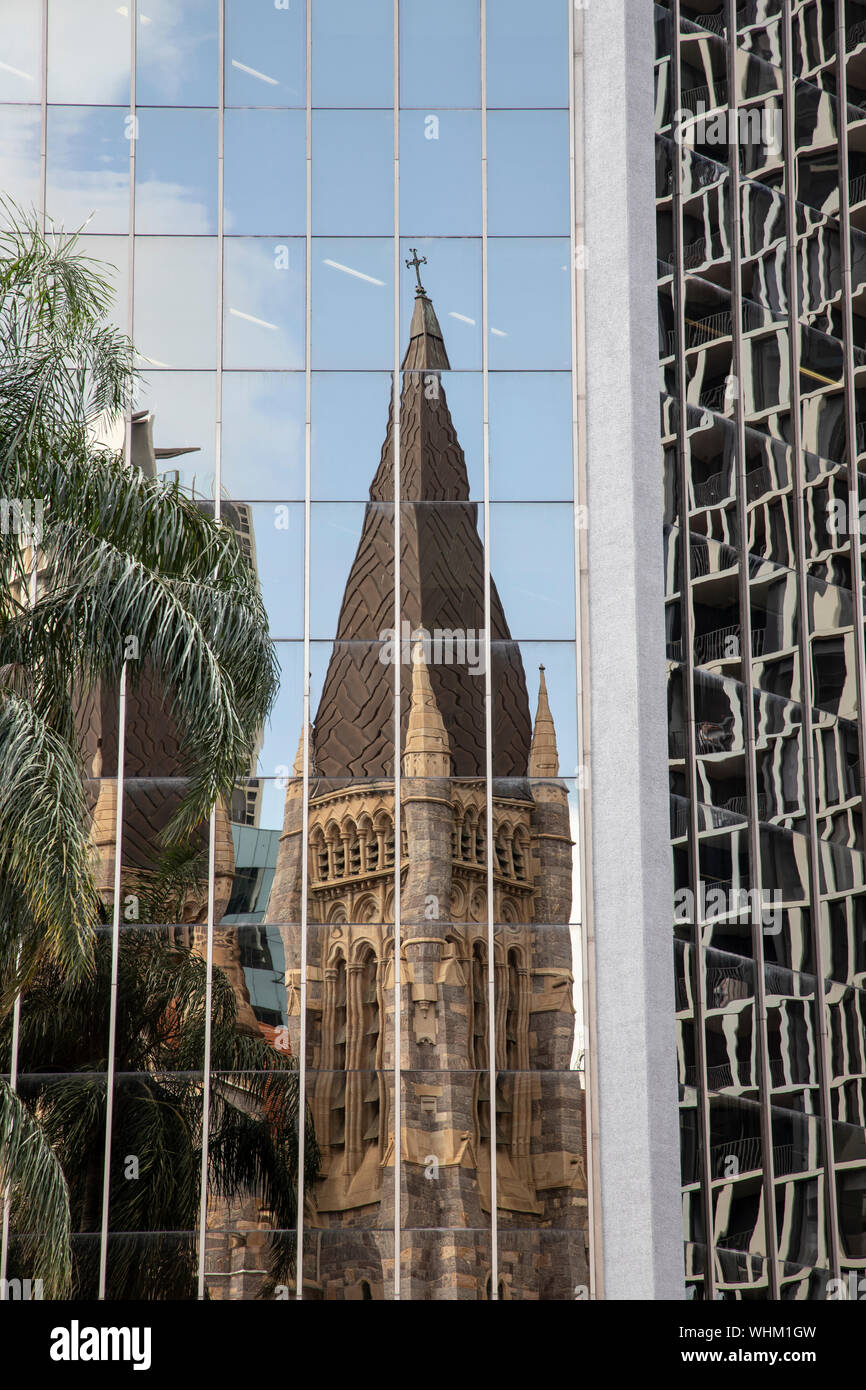 La giustapposizione di vecchio e nuovo con la Cattedrale di St Stephens e un moderno grattacielo di vetro nell'area del centro cittadino di Brisbane, Australia Foto Stock