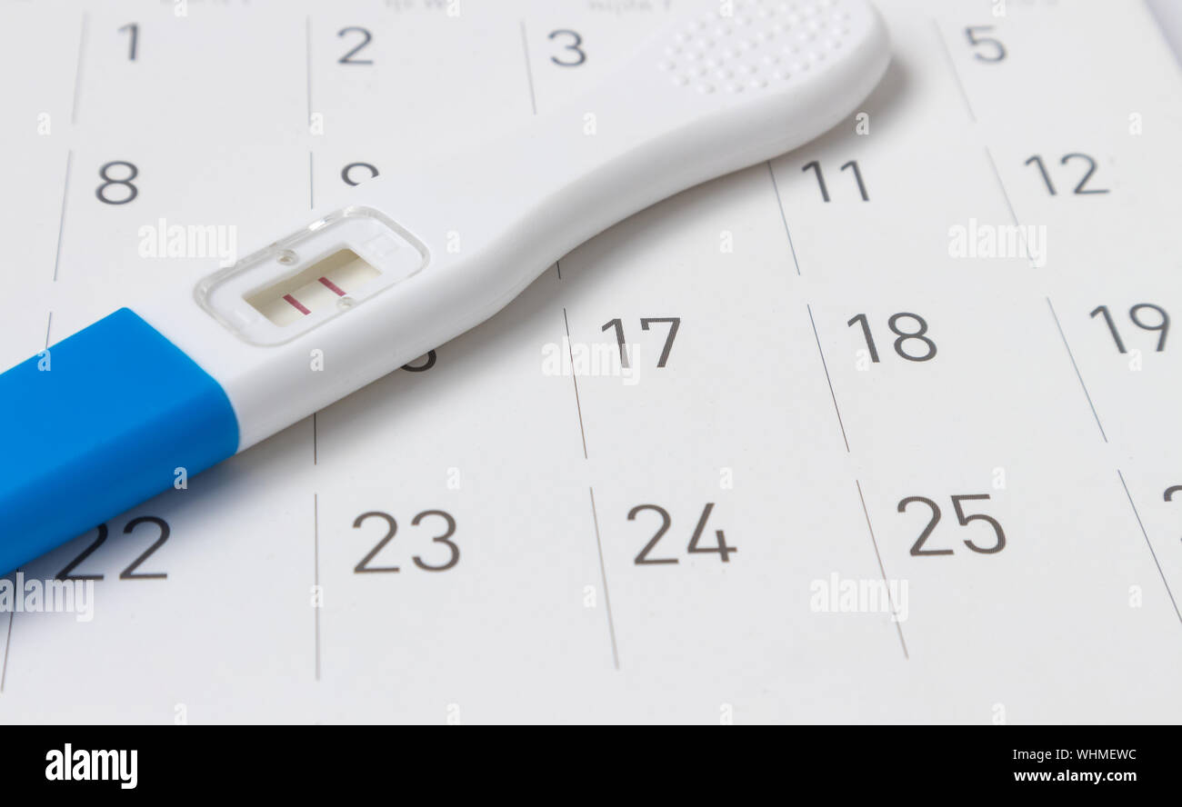 Close-up di gravidanza Tester sul calendario Foto Stock