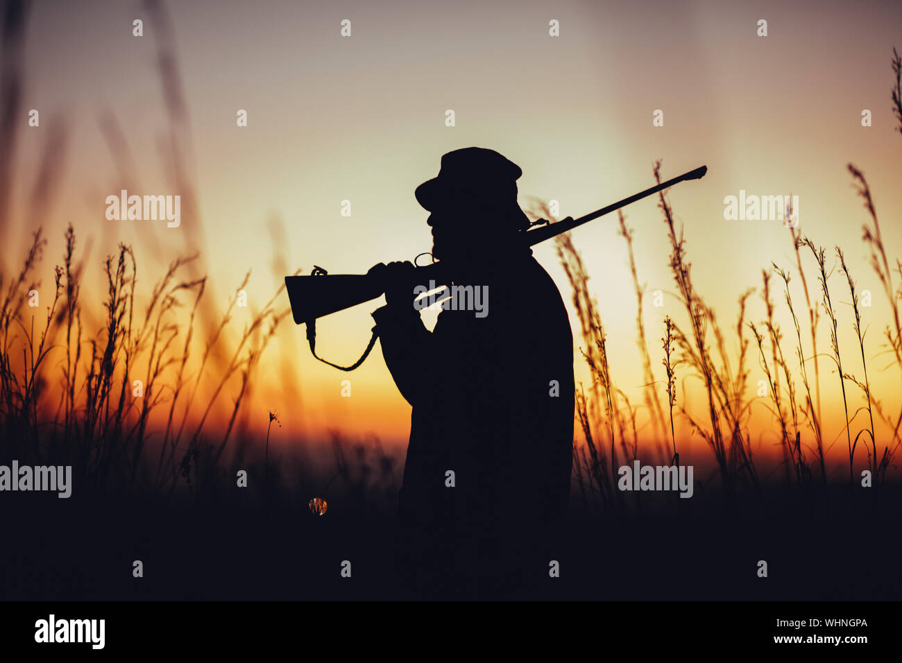Uomo con la pistola al tramonto Foto Stock