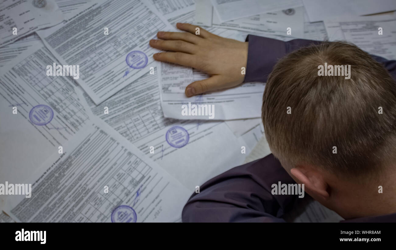 Un uomo con i documenti aziendali e i contratti. Situazione di crisi. Problemi con le banche, i debiti sui pagamenti, trasferimenti e prestiti. Foto Stock