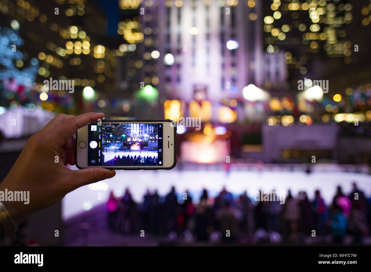 Un turista è di scattare le foto con il suo telefono cellulare al Rockefeller tower a New York, Stati Uniti d'America. Foto Stock