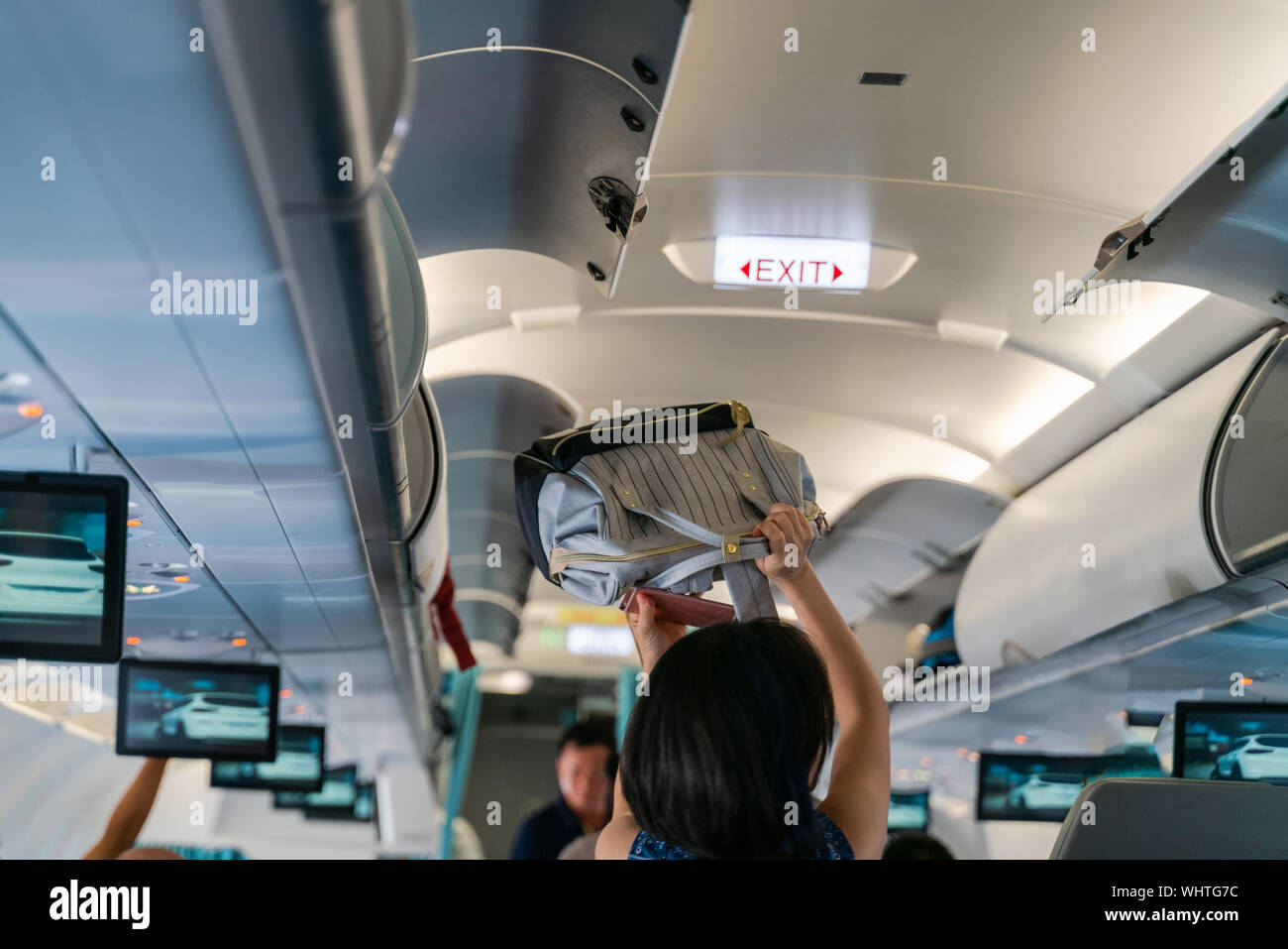 Mano togliere i bagagli a mano. Borsa cabina sulla mensola superiore in  aereo Foto stock - Alamy