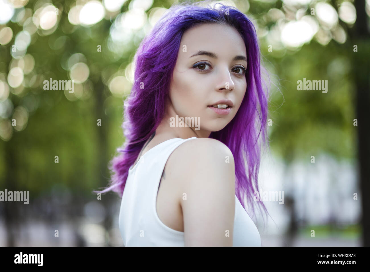 Giovane e bella viola hairy ragazza camminare al tramonto in un parco della città. San Pietroburgo, New Holland Foto Stock