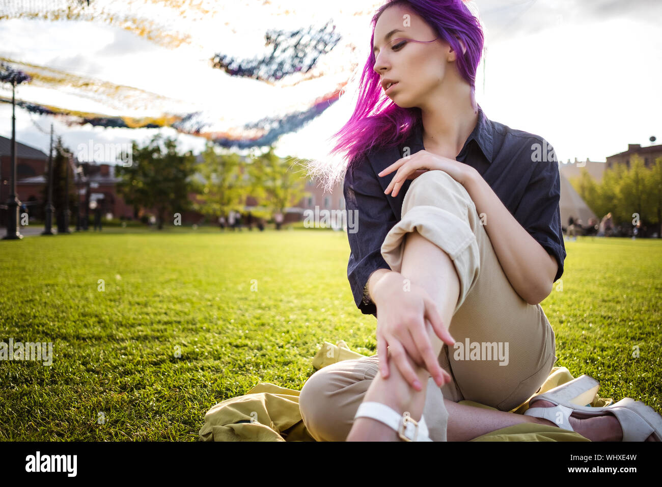 Giovane e bella viola hairy ragazza camminare al tramonto in un parco della città. San Pietroburgo, New Holland Foto Stock
