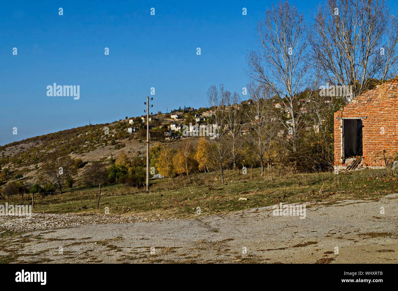 Incredibile vista autunnale di glade, collina, foresta con alberi decidui e residenziale quartiere di grazioso villaggio Zhrebichko, Bratsigovo comune, R Foto Stock