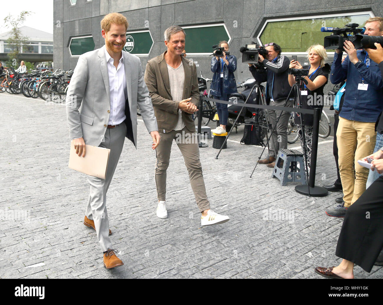 Sander Groet (a destra), un partner a un'DAM torre in Amsterdam saluta il Duca di Sussex come egli arriva per il lancio di un nuovo viaggio partnership di settore. Foto Stock