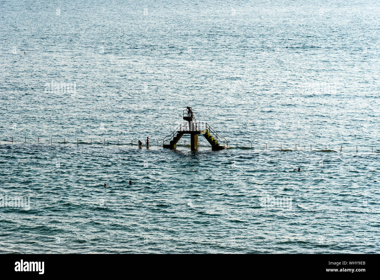 Persone che saltano dal trampolino in piscina presso la spiaggia di Saint Malo a marea alta Foto Stock