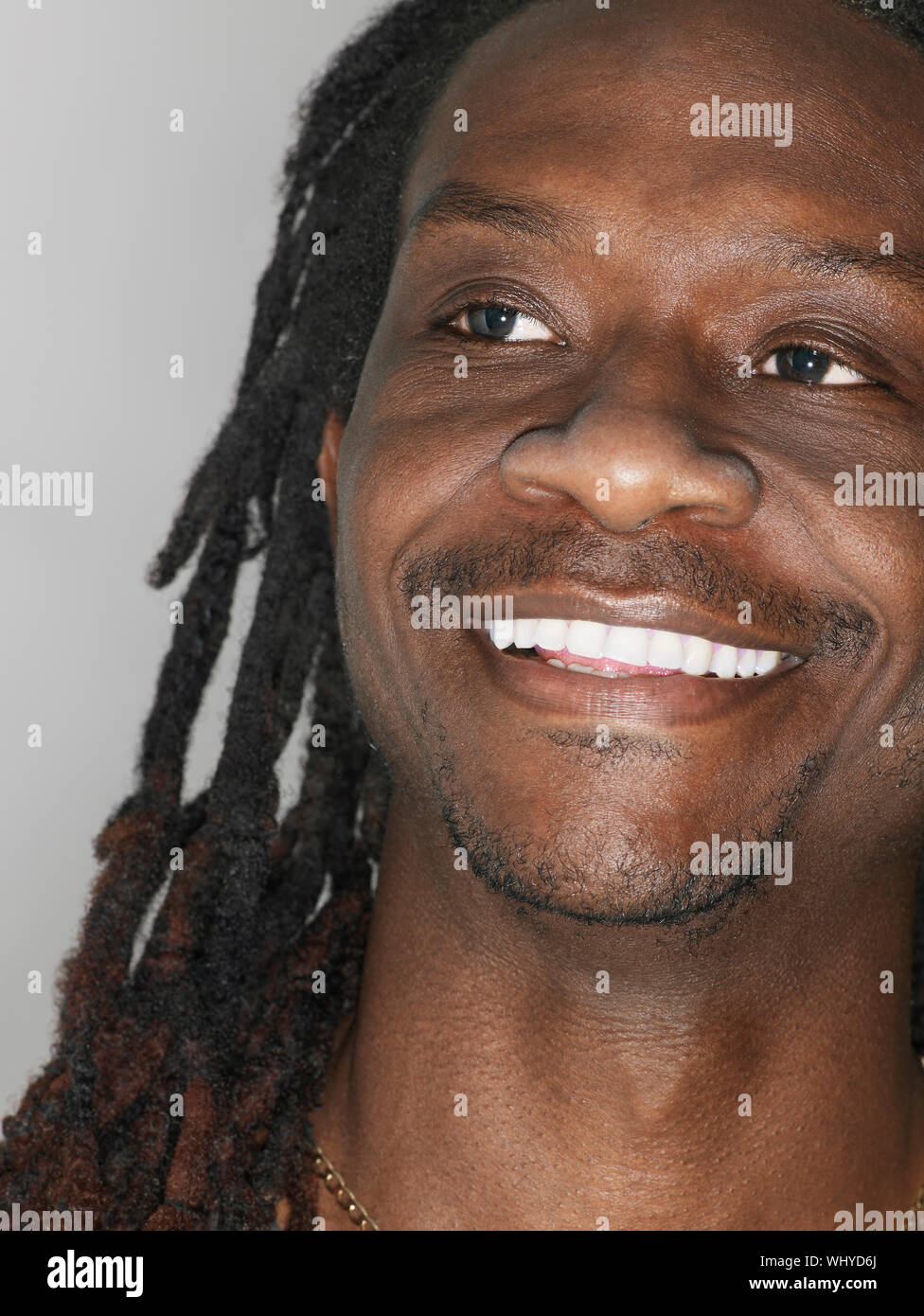 Primo piano della African American uomo sorridente su sfondo grigio Foto Stock