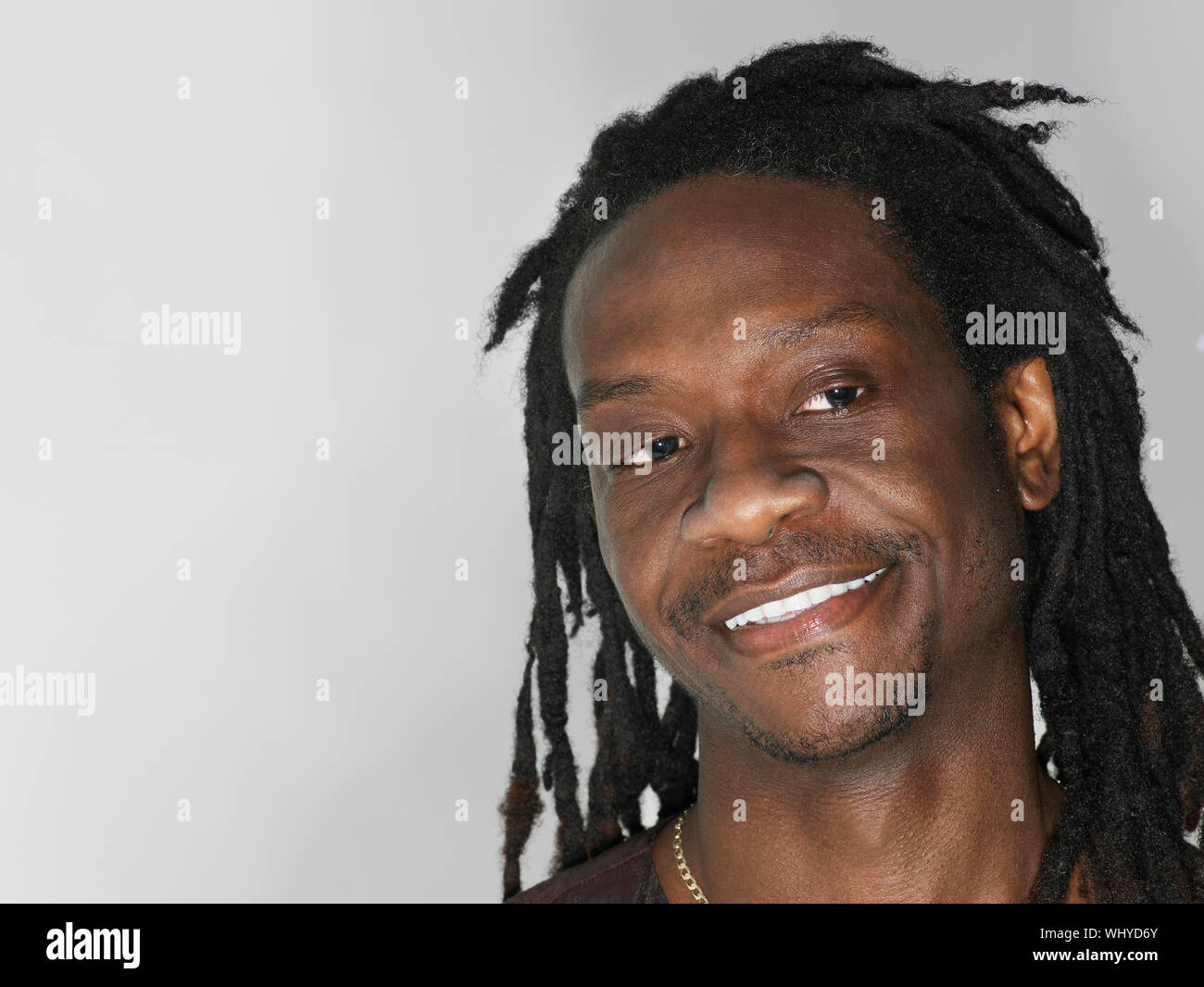 Primo piano della African American uomo sorridente su sfondo grigio Foto Stock