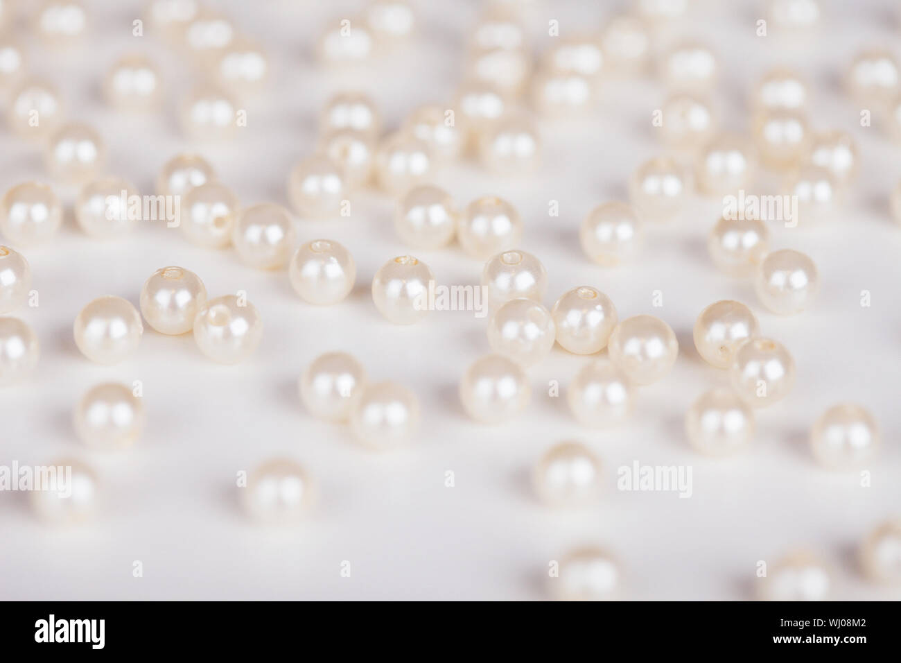 La dispersione di fake perle su una superficie luminosa Foto Stock