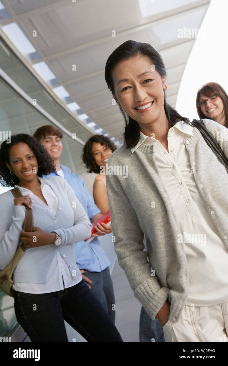 L insegnante e gli studenti sorridente al di fuori della scuola, ritratto Foto Stock