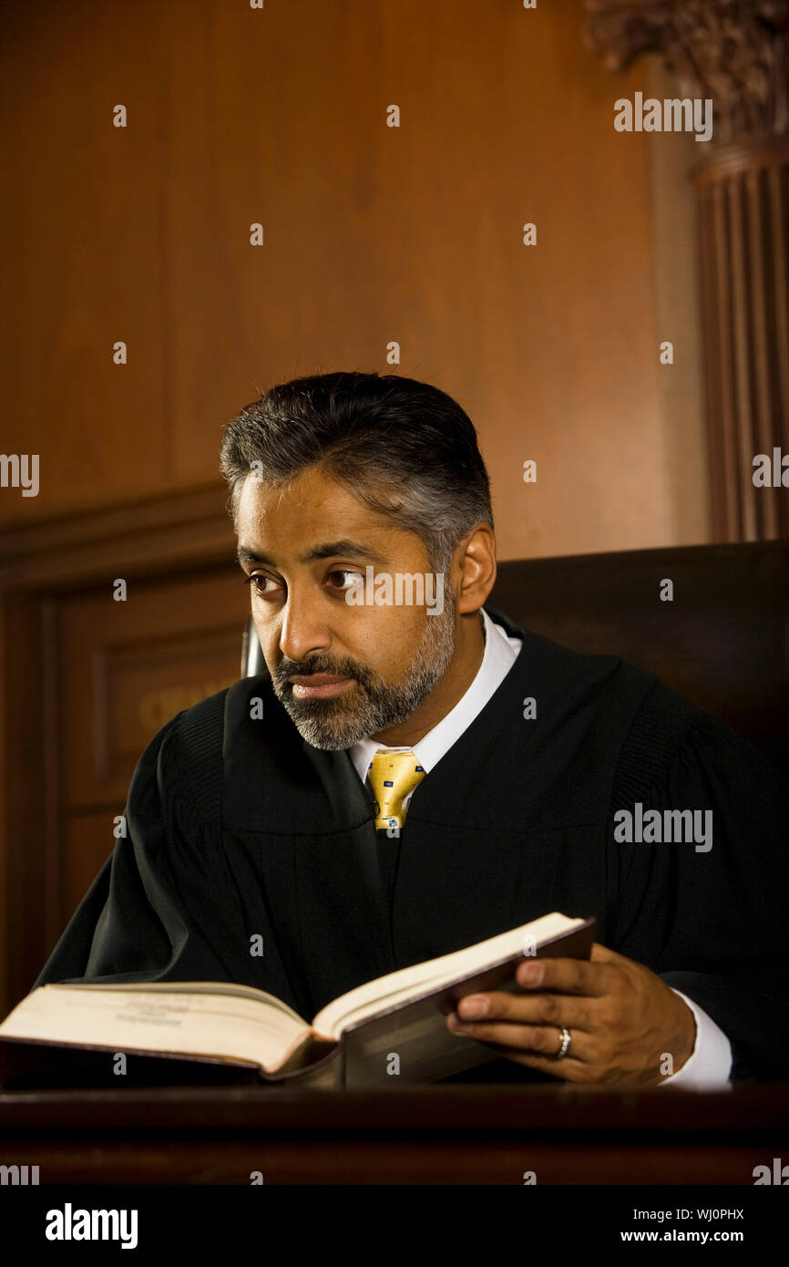 Medioevo giudice maschio con libro guardando lontano nella sala di corte Foto Stock