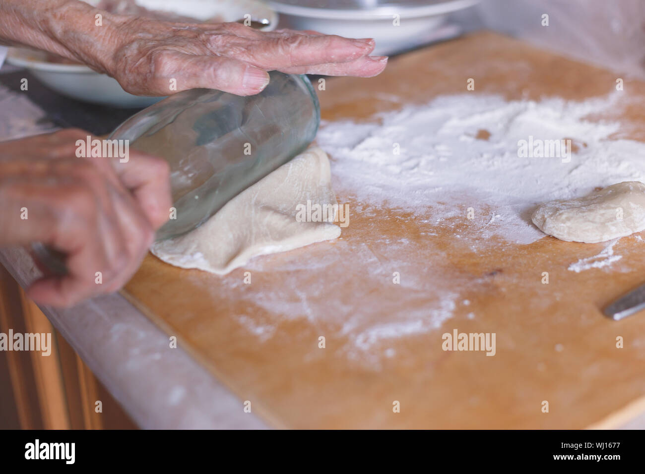 Le mani della vecchia donna sulla pasta appiattita. Foto Stock