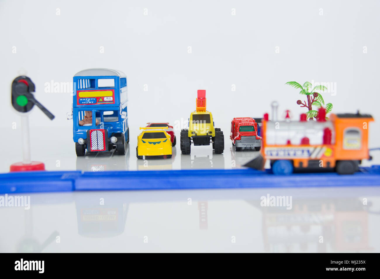 Macchinine giocattolo in attesa al passaggio ferroviario Foto Stock
