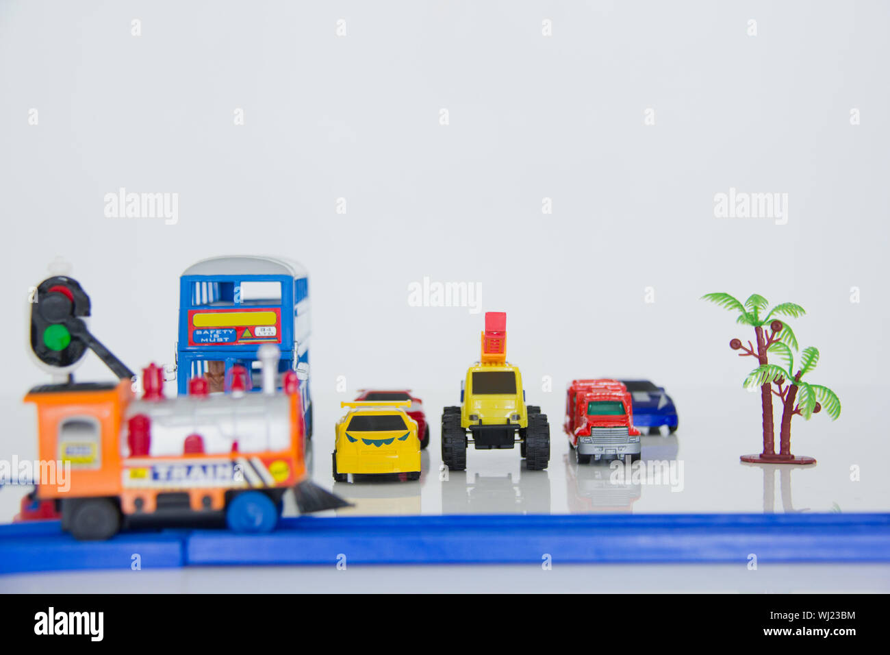 Macchinine giocattolo in attesa al passaggio ferroviario Foto Stock