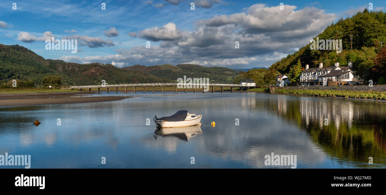 Panorama del legno di ponte a pedaggio, piscina e George terzo albergo a Penmaenpool in Snowdonia, il Galles del Nord. Una piccola barca in ormeggiata in primo piano. Foto Stock