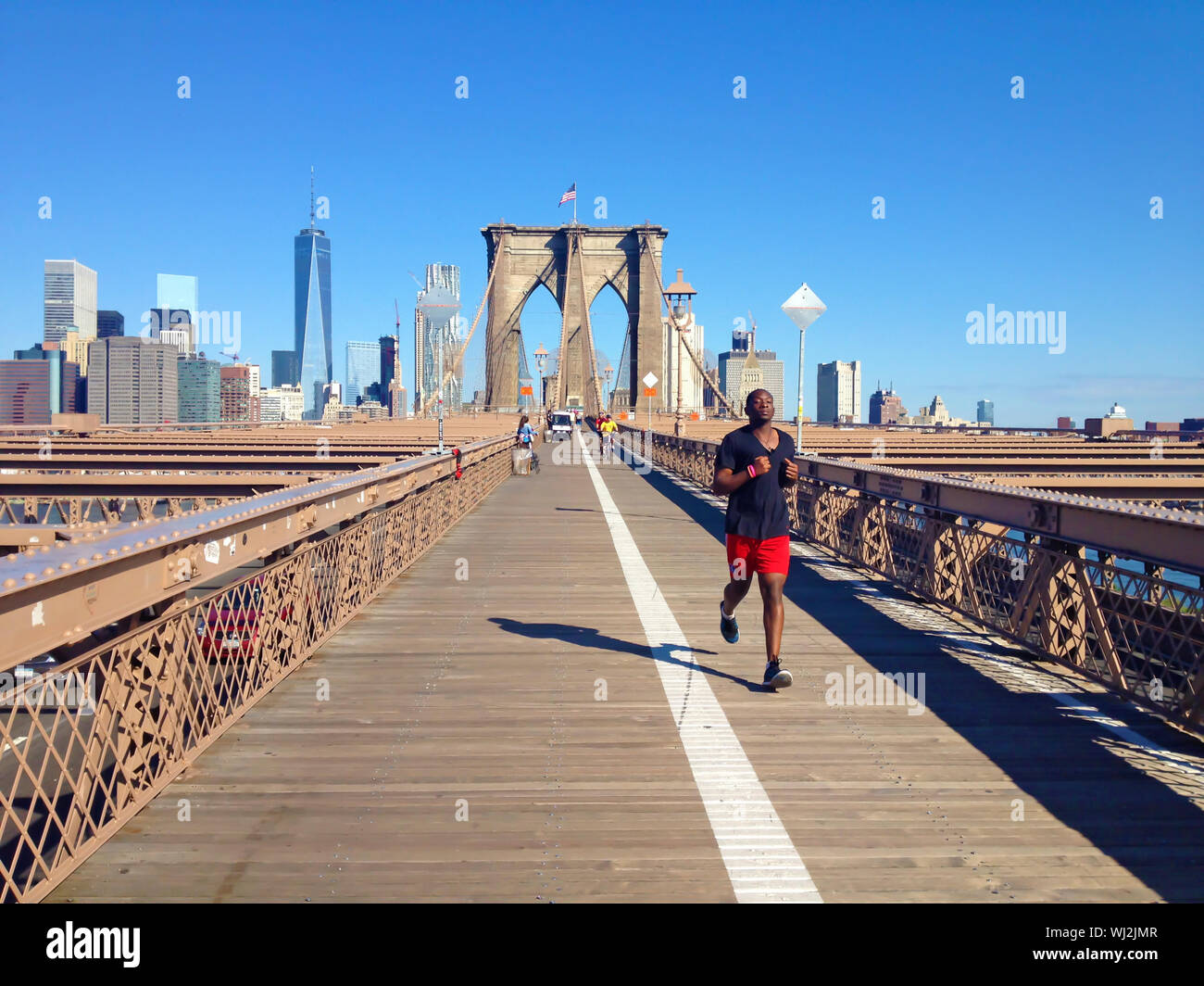 Uomo in esecuzione oltre il ponte di Brooklyn a New York Foto Stock