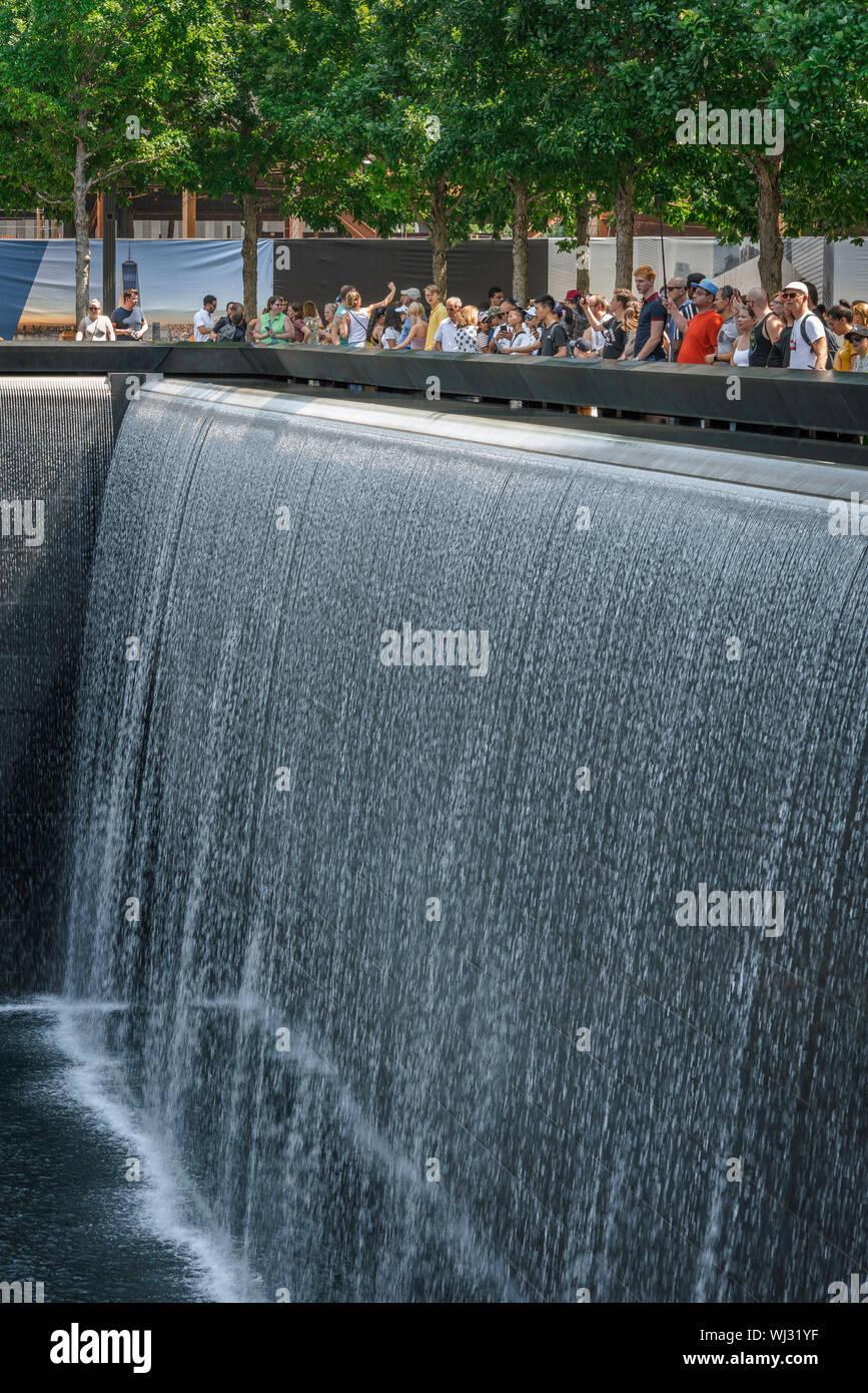 9/11 Memorial, vista della gente che guarda all'enorme fontana della North Tower che riflette la piscina al 9/11 Memorial site a Manhattan, New York City. Foto Stock