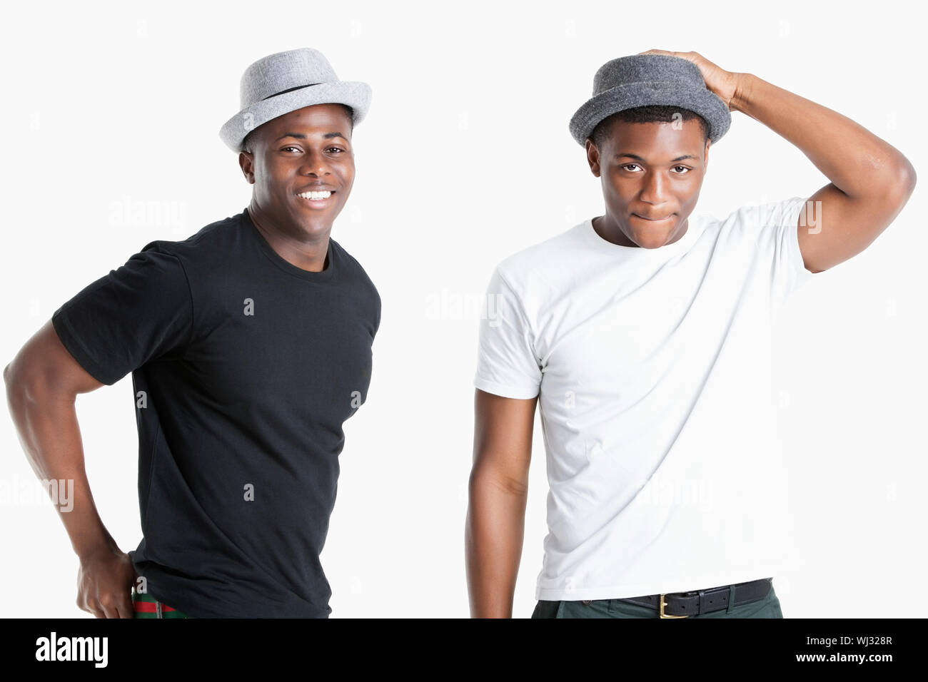 Ritratto di felice giovane africano americano uomini indossare cappelli su sfondo grigio Foto Stock