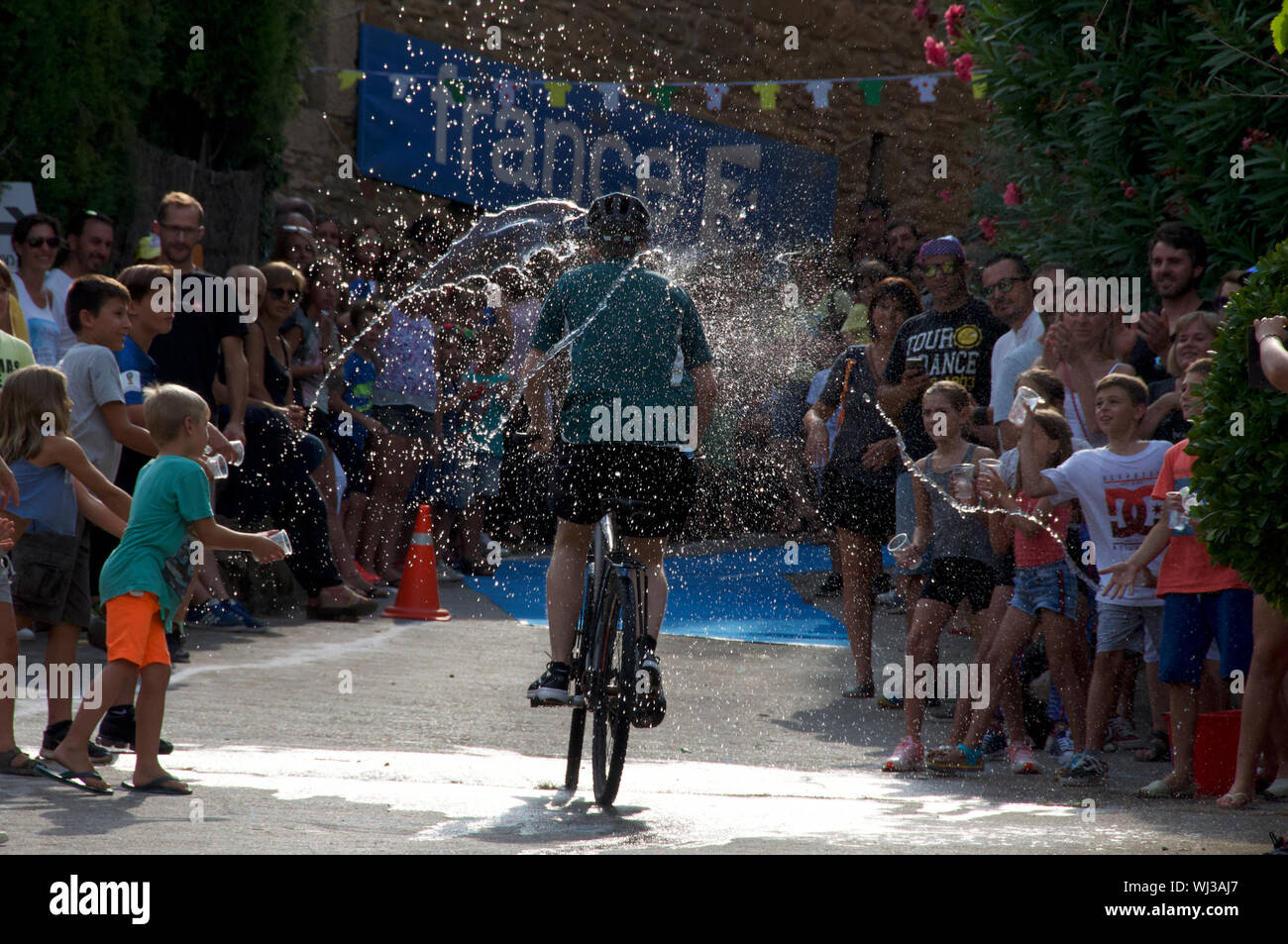 Azione dal ciclo di razza, un breve tratto in salita, nel villaggio di Mianigues, Pla d'lestany, Girona, Spagna. I concorrenti sono cosparsi di fan. Foto Stock