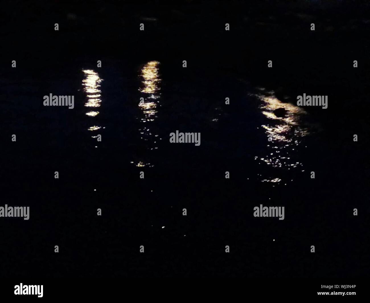 La riflessione di luce sul Lago di notte Foto Stock