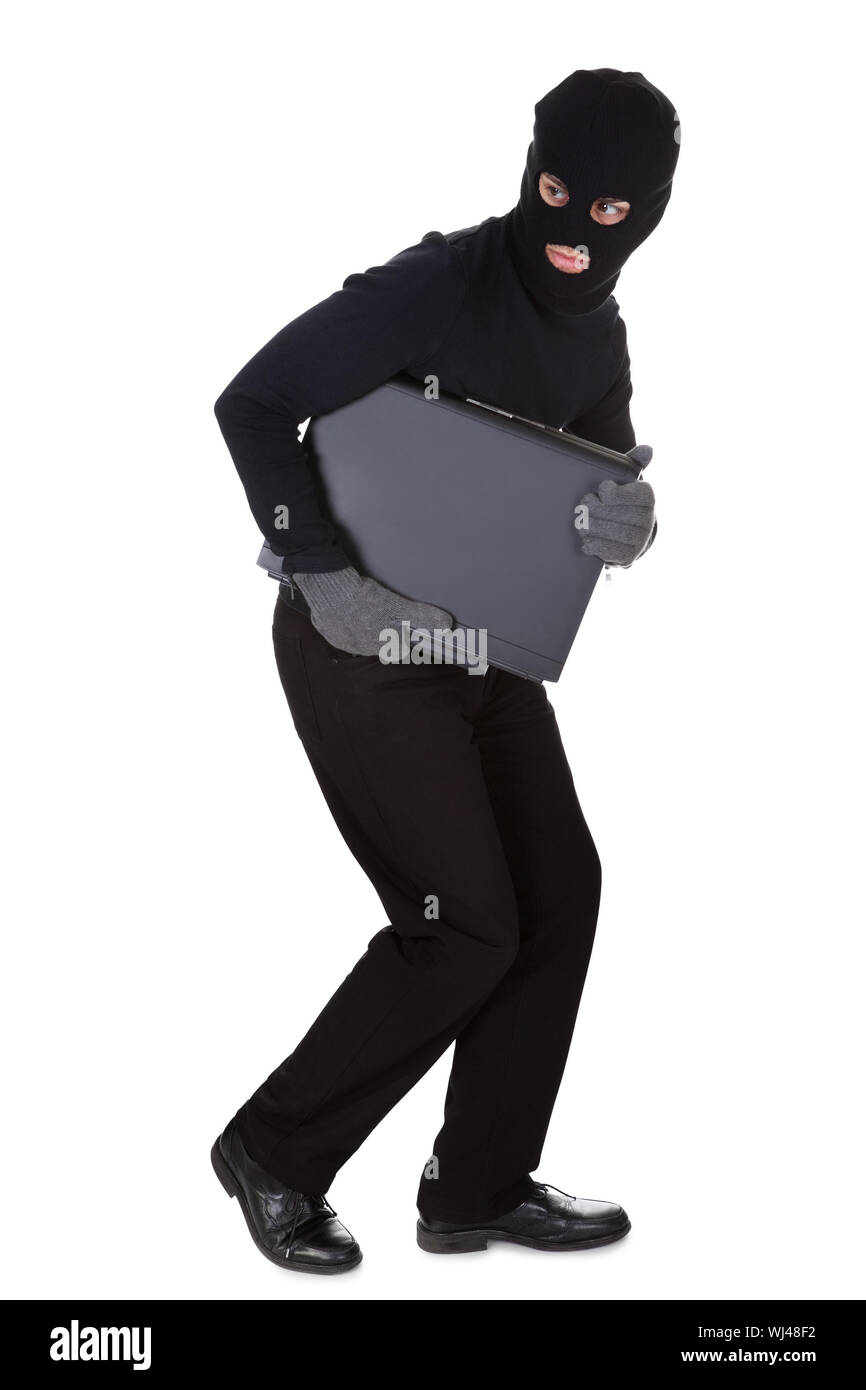 Ladro vestito di nero e con indosso un passamontagna rubare un computer  portatile e la realizzazione di una fuga furtif isolato su bianco Foto  stock - Alamy